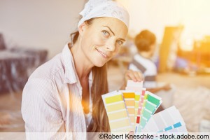 Frau als Heimwerker mit Auswahl an Wandfarbe